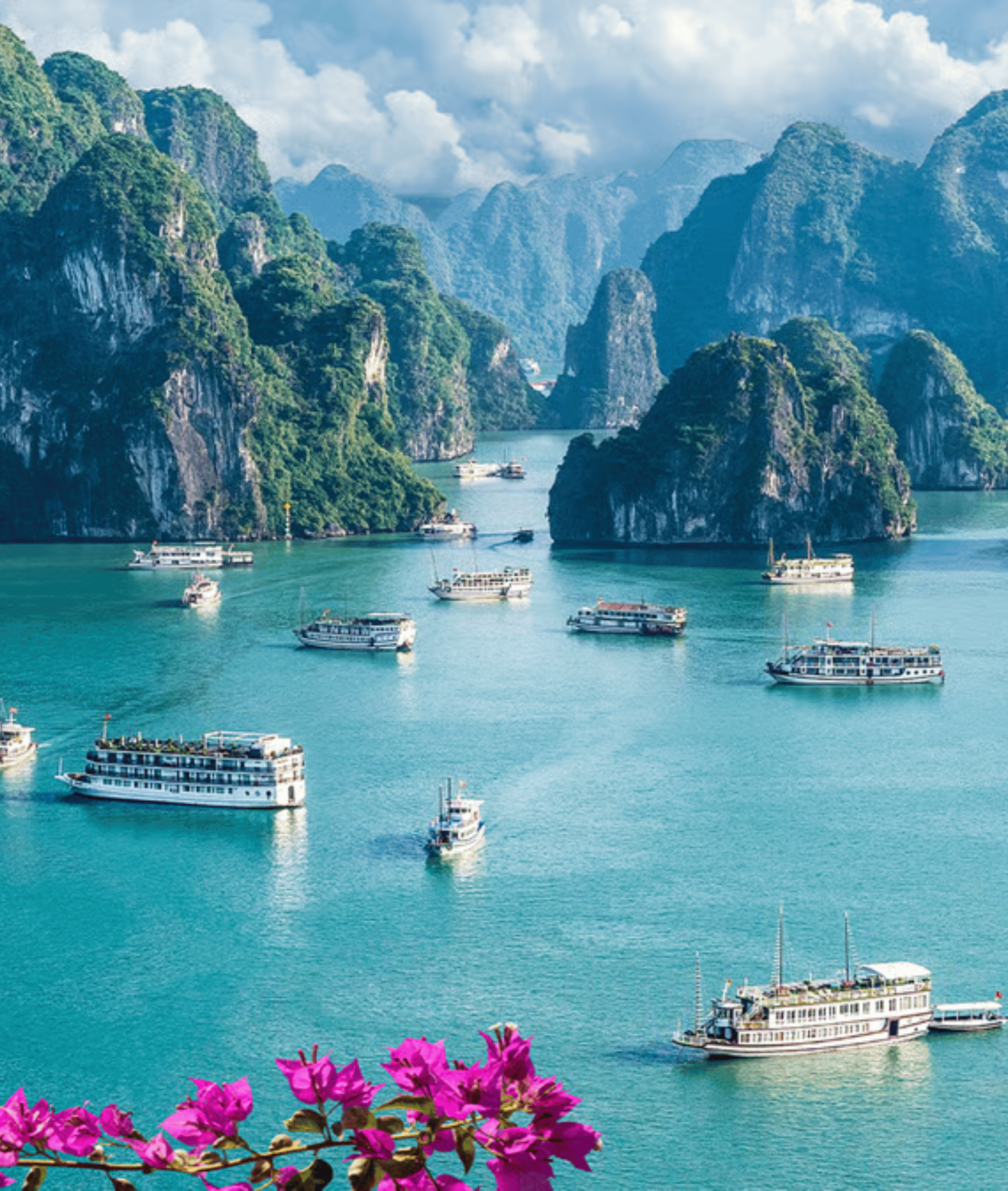 Scenic image of Vietnam with boats sailing on the water with mountains in the background.